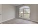 A bright bedroom features a neutral carpet and a large arched window overlooking the front yard at 2075 Sea Hero Ct, Indianapolis, IN 46234