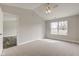 A neutral bedroom has plush carpets, a large window, and a vaulted ceiling at 2075 Sea Hero Ct, Indianapolis, IN 46234