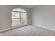 A bright bedroom features a neutral carpet and a large arched window overlooking the front yard at 2075 Sea Hero Ct, Indianapolis, IN 46234