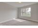 A bedroom has neutral carpet and paint with a view of the front yard through a large window at 2075 Sea Hero Ct, Indianapolis, IN 46234