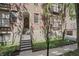 Brick apartment building exterior with stairs leading to an arched entryway and lush, green landscaping at 226 N Cleveland St # 226C, Indianapolis, IN 46204