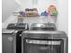 Modern laundry room featuring front loading washer and dryer with storage shelf and organized supplies above at 226 N Cleveland St # 226C, Indianapolis, IN 46204