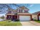 Inviting two-story home features a brick facade, red shutters, attached two car garage, and lakeside lot at 2441 Longleaf Dr, Greenwood, IN 46143