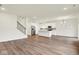 Open-concept living room with kitchen, stainless steel appliances, vinyl flooring, recessed lights and staircase at 2712 Glade Ave, Plainfield, IN 46168