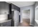 Sleek kitchen featuring modern stainless steel refrigerator, dark cabinets, and bright backsplash tiles at 2833 Hervey St, Indianapolis, IN 46203