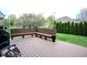 Beautiful wooden backyard deck features built in seating with outdoor space and manicured landscaping at 3389 Grant Ct, Columbus, IN 47203