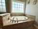 Bright bathroom features a soaking tub with tile surround and a large window at 3389 Grant Ct, Columbus, IN 47203