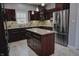 Updated kitchen with stainless steel appliances, dark wood cabinets, granite countertops, and tile floors at 3389 Grant Ct, Columbus, IN 47203