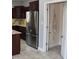 Kitchen showcasing stainless steel refrigerator, dark cabinets, granite countertops and an open pantry at 3389 Grant Ct, Columbus, IN 47203