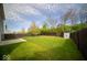 Large backyard with lush green grass, a storage shed, and a wooden fence at 4622 Crosby Buck Dr, Indianapolis, IN 46237