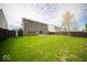 Wide shot of the backyard with a well-kept lawn, a dark wooden fence, and a patio area at 4622 Crosby Buck Dr, Indianapolis, IN 46237