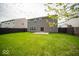 Spacious backyard featuring a well-maintained lawn, privacy fence, and a sliding glass door to the home at 4622 Crosby Buck Dr, Indianapolis, IN 46237