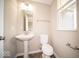 Cozy half-bathroom featuring a pedestal sink, toilet, and convenient grab bars at 4622 Crosby Buck Dr, Indianapolis, IN 46237