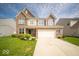 Charming two-story home with a well-manicured lawn, brick facade, and attached two-car garage at 4622 Crosby Buck Dr, Indianapolis, IN 46237