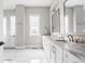 Bright bathroom featuring marble countertops, double sinks, and large window with natural light at 496 Bridgemont Ln, Carmel, IN 46032