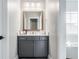 Stylish gray vanity with a light countertop and wood-framed mirror in a well-lit bathroom at 496 Bridgemont Ln, Carmel, IN 46032