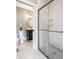 Elegant bathroom boasts a glass-enclosed shower and adjacent powder room with modern fixtures and finishes at 496 Bridgemont Ln, Carmel, IN 46032