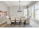 Bright dining room with large windows, modern chandelier, and seating for eight at 496 Bridgemont Ln, Carmel, IN 46032
