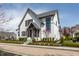 Charming two-story home with white brick, black trim, and lush landscaping at 496 Bridgemont Ln, Carmel, IN 46032