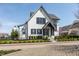 Charming two-story home with white brick, black trim, and landscaped front yard at 496 Bridgemont Ln, Carmel, IN 46032