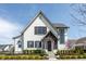 Charming two-story home with white brick, black trim, and covered front porch at 496 Bridgemont Ln, Carmel, IN 46032