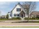 Charming two-story home with white brick, black trim, and landscaped front yard at 496 Bridgemont Ln, Carmel, IN 46032