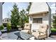 Outdoor fireplace with comfortable seating, surrounded by mature landscaping at 496 Bridgemont Ln, Carmel, IN 46032