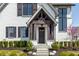 Close-up of the home's entry featuring a covered porch and manicured landscaping at 496 Bridgemont Ln, Carmel, IN 46032