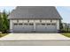 Three car detached garage with a gray shingle roof and neutral colored doors at 496 Bridgemont Ln, Carmel, IN 46032