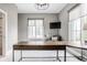 Bright home office with an L-shaped desk, large windows with shades, and comfortable seating area at 496 Bridgemont Ln, Carmel, IN 46032