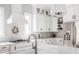 Bright kitchen featuring stainless appliances, white cabinetry, marble counters, and a designer faucet at 496 Bridgemont Ln, Carmel, IN 46032