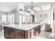 Open kitchen with center island featuring marble countertop and view to the open concept living area at 496 Bridgemont Ln, Carmel, IN 46032
