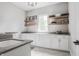 Well-organized laundry room with ample cabinetry, countertop space, shelving, and bright natural light at 496 Bridgemont Ln, Carmel, IN 46032