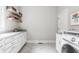 Well-appointed laundry room with generous countertop space, storage cabinets, shelving, and modern washer at 496 Bridgemont Ln, Carmel, IN 46032