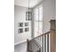 Bright staircase featuring black metal railing and large window, creating an inviting and stylish entry at 496 Bridgemont Ln, Carmel, IN 46032