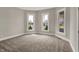 Bright, carpeted room with three large windows providing abundant natural light at 508 Miller Ave, Shelbyville, IN 46176