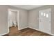 Hallway with an entry door, wood-look flooring, and bathroom with vanity and toilet at 508 Miller Ave, Shelbyville, IN 46176
