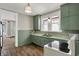 Charming kitchen features green cabinetry, light countertops, and wood-look floors at 508 Miller Ave, Shelbyville, IN 46176