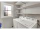 Bright laundry area featuring a washing machine and dryer, complemented by convenient shelving at 508 Miller Ave, Shelbyville, IN 46176