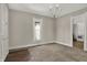 Neutrally decorated living room with plush carpeting, a statement chandelier, and natural light at 508 Miller Ave, Shelbyville, IN 46176