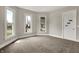 A bright living room with three windows, neutral walls, and carpet at 508 Miller Ave, Shelbyville, IN 46176