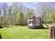 Well-maintained backyard with lush lawn, bordered by mature trees, featuring trampoline at 5236 Skipping Stone Dr, Indianapolis, IN 46237