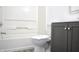 Clean bathroom with a toilet, a white tub with shower, and a gray vanity at 5236 Skipping Stone Dr, Indianapolis, IN 46237