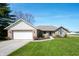 Charming single-story brick home with an attached garage and a well-manicured front lawn under a clear blue sky at 5500 W Sudbury Dr, Muncie, IN 47304