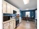 Open kitchen features white cabinets, granite countertops, stainless steel appliances, and an adjacent dining area at 5500 W Sudbury Dr, Muncie, IN 47304