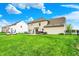 Expansive backyard with manicured lawn, a fire pit area, a patio, and a neighboring house at 5595 Auburndale Dr, Bargersville, IN 46106