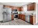 Kitchen with stainless appliances, granite counters, wood cabinets and woodgrain floors at 5595 Auburndale Dr, Bargersville, IN 46106