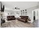 Spacious living room featuring leather sofas, wood flooring, and view of the fireplace and open to the kitchen at 5595 Auburndale Dr, Bargersville, IN 46106