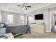 Bright main bedroom with carpet, a tray ceiling, and large windows overlooking the home's exterior at 5595 Auburndale Dr, Bargersville, IN 46106
