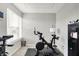 A dedicated workout room with a Peloton bike, equipment, natural light, and ample space for exercise at 5595 Auburndale Dr, Bargersville, IN 46106